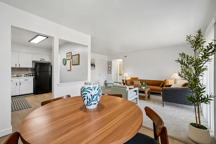 Inviting open-concept living area with stylish decor, featuring a cozy seating space, elegant dining table, and modern kitchen with sleek appliances.