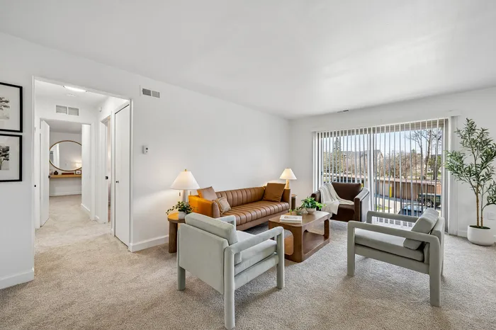 Bright and inviting living room showcasing modern furniture, elegant decor, and expansive windows offering natural light.