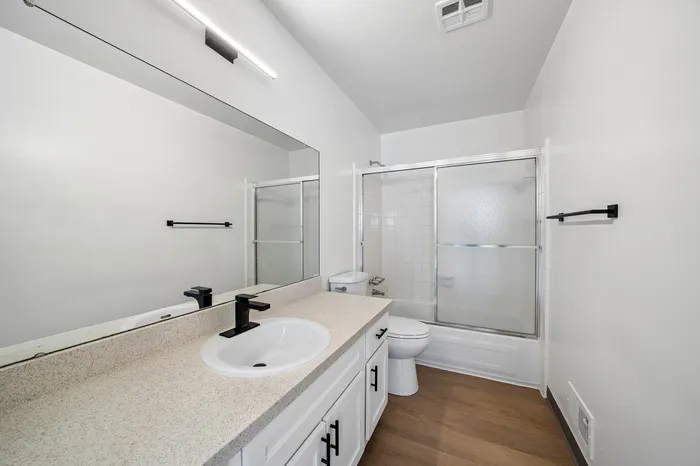 Modern bathroom featuring elegant fixtures, sleek countertop, and a glass-enclosed shower.