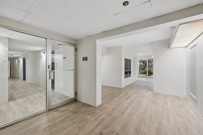 Bright and welcoming apartment entrance with chic wood flooring and garden view.