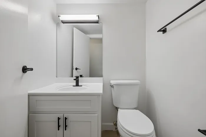 Sleek modern bathroom featuring a pristine white vanity, contemporary fixtures, and minimalist decor.