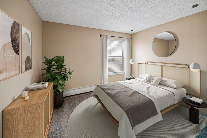 Elegant bedroom showcasing a modern bed with a sleek wooden headboard, accented by minimalist decor and ample natural light.