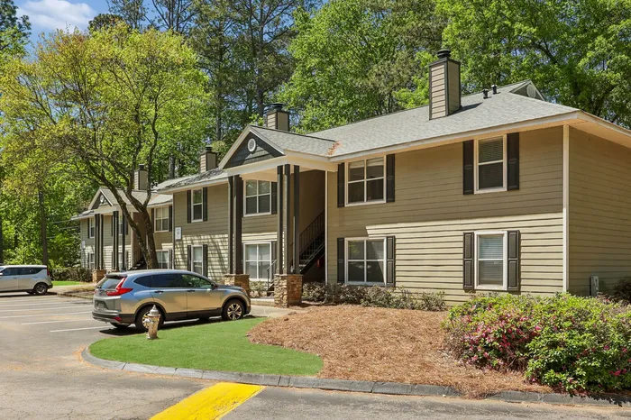 Charming apartment complex surrounded by lush greenery, featuring modern two-story units with a tranquil outdoor setting.