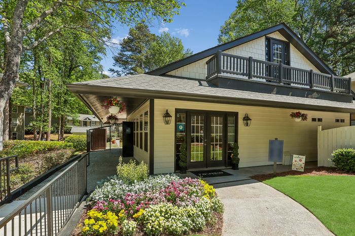 Charming residence with a beautifully landscaped front garden, welcoming entryway, and elegant design, surrounded by lush greenery.