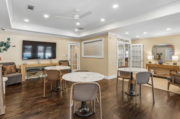 Inviting communal living space with elegant marble-top tables, plush seating, and warm wooden accents, ideal for social gatherings.