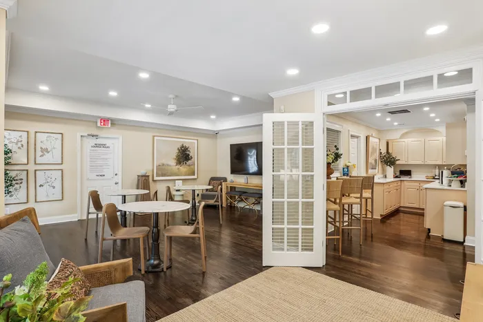 Charming apartment interior with a cozy lounge area, elegant dining tables, and a modern kitchen, perfect for entertaining.