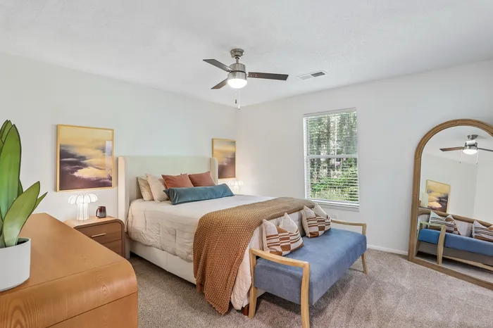 Elegant bedroom with abundant natural light, stylish decor, and a cozy seating area.