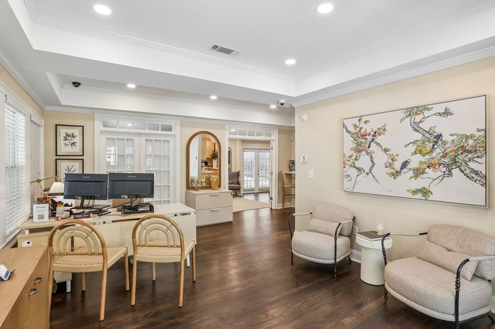 Elegant home office space with stylish decor, featuring a modern desk with dual monitors, comfortable seating, and artistic wall art.