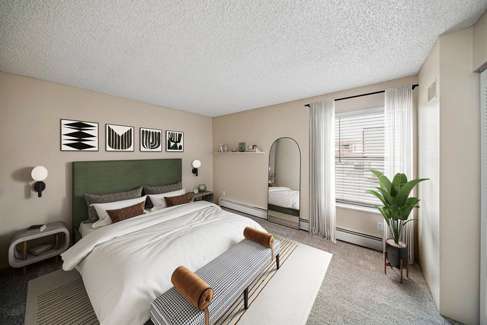 Inviting bedroom with stylish decor, featuring a plush green headboard, modern art, and a cozy atmosphere.