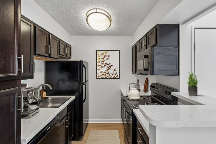 Chic kitchen with dark wood cabinets, modern appliances, and elegant wall art creating a sophisticated ambiance.