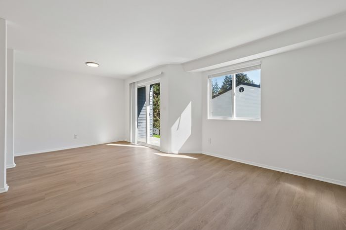 Bright and airy living space featuring sleek wooden floors and large windows letting in natural light.
