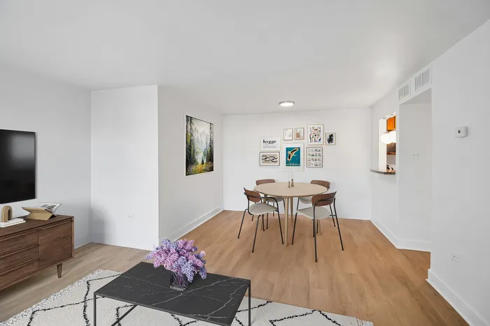 Contemporary living space featuring a cozy dining area, modern decor, and elegant wood flooring.
