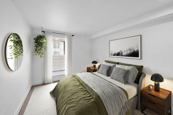 Modern bedroom with a cozy bed, elegant decor, and natural light streaming through large windows, creating a serene retreat.
