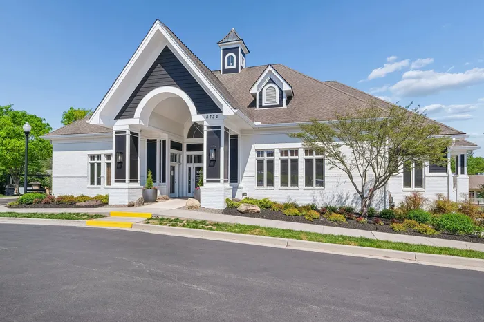 Charming single-story home with a striking modern facade, featuring elegant white brick and contrasting dark accents, set in a beautifully landscaped neighborhood.