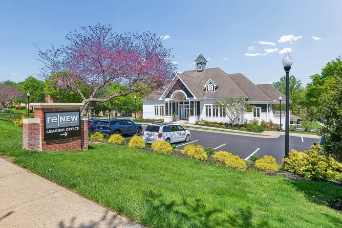 Inviting leasing office surrounded by lush greenery and vibrant blossoms, offering a welcoming atmosphere at ReNew Howard Crossing.