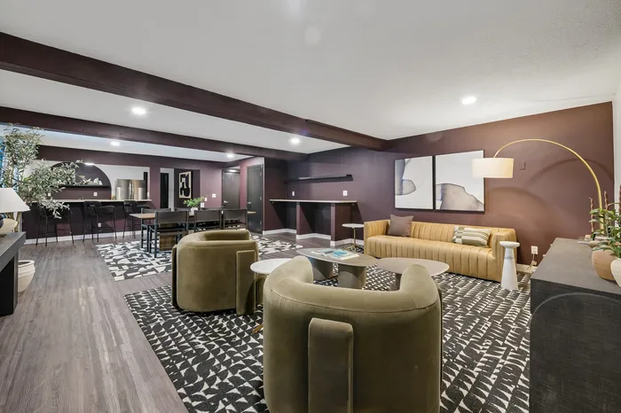 Chic living space with modern decor featuring comfortable seating, an elegant sofa, and stylish artwork under warm lighting.