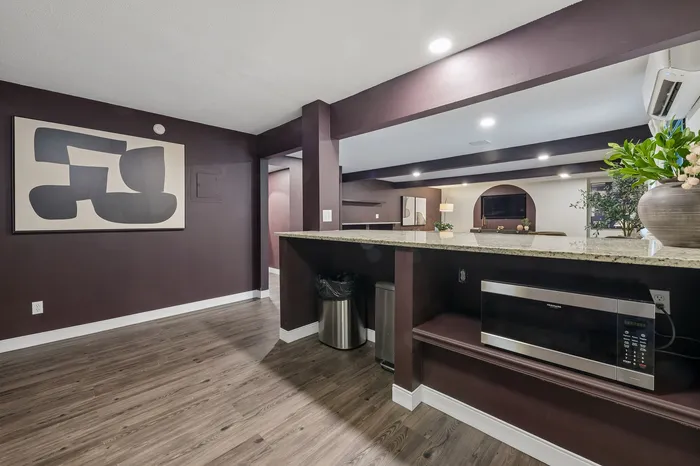 Modern apartment with elegant dark wood flooring and stylish decor, featuring a spacious open kitchen and living area with contemporary design elements.