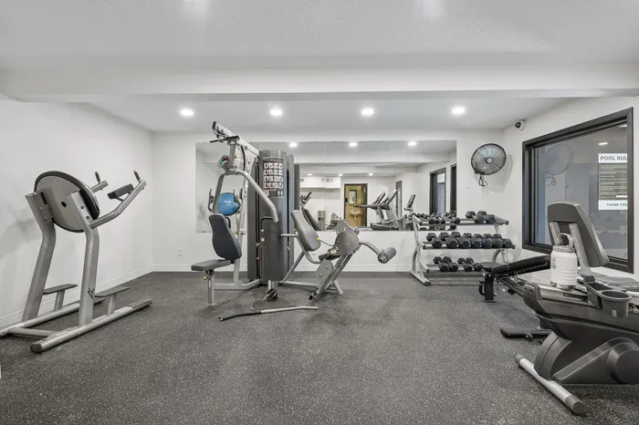 Modern fitness center with state-of-the-art equipment, including weights and cardio machines, in a bright, spacious setting.
