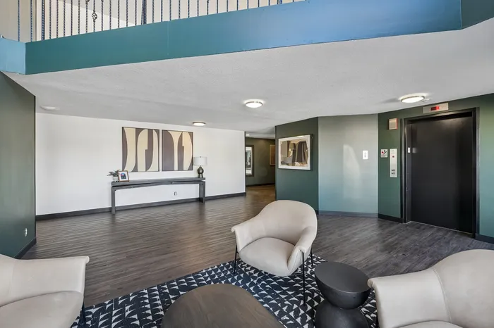 Elegant lobby featuring modern decor, luxurious seating, stylish artwork, and sleek elevator access.