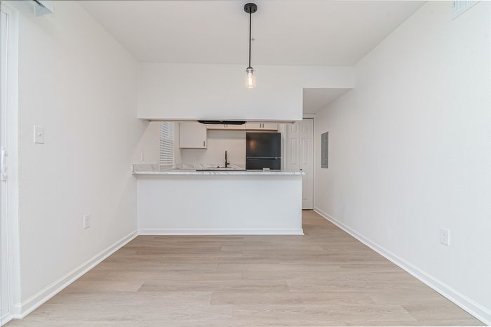 Contemporary open-concept kitchen with elegant marble countertops and sleek black appliances, perfect for modern living.