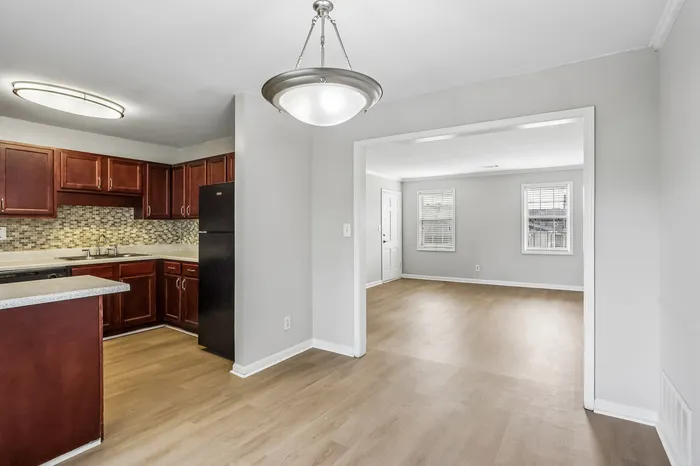 Bright and modern kitchen with dark wood cabinets and spacious open living area, perfect for entertaining.