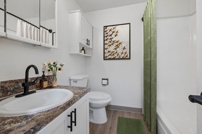 Chic bathroom featuring elegant decor with floral accents, modern fixtures, and a stylish patterned wall art.