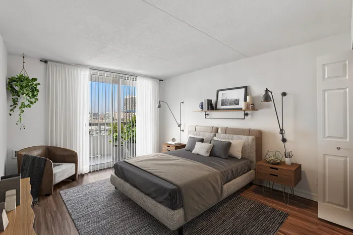 Bright and airy bedroom with modern decor, featuring a cozy bed, elegant lighting, and a large window with city views.