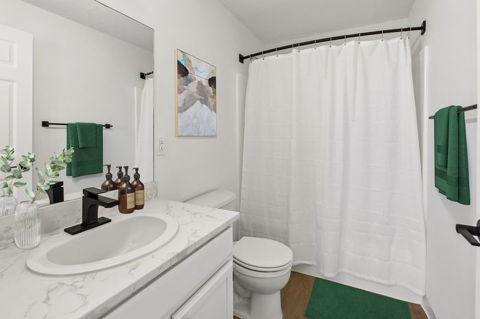 Elegant bathroom with a modern marble countertop, sleek black faucet, and chic decor, offering a tranquil oasis feel.