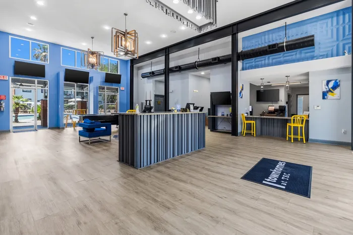 Modern clubhouse interior with vibrant blue accents, stylish lighting, and welcoming seating area at luxury apartments.