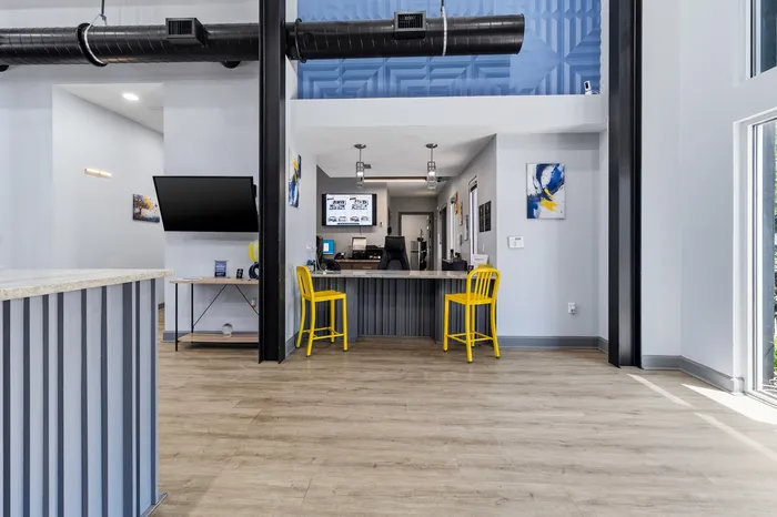Modern and welcoming office interior featuring sleek design, vibrant yellow chairs, and an open layout with stylish decor accents.