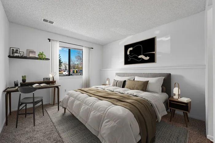 Inviting bedroom with modern decor, featuring a cozy bed, stylish desk, and large window showcasing natural light.