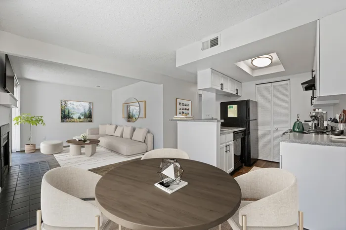 Modern open-concept living area with chic kitchen, cozy lounge, and inviting dining space, bathed in natural light.