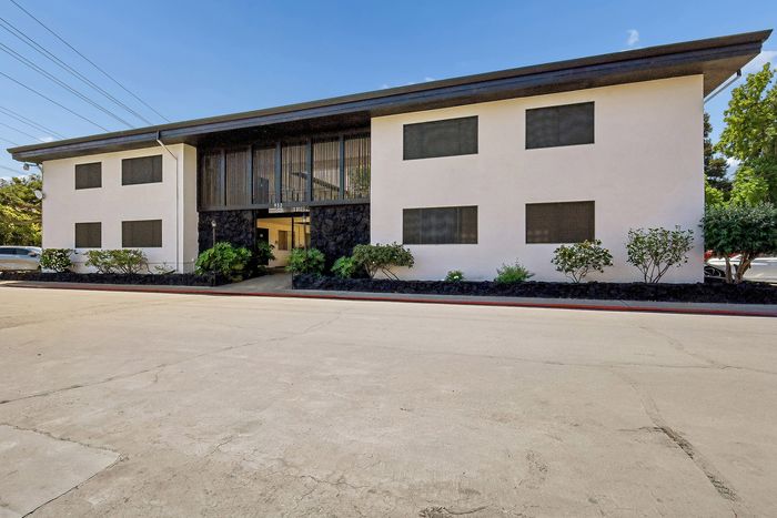 Modern apartment building showcasing sleek architecture with lush landscaping, perfect for urban living.