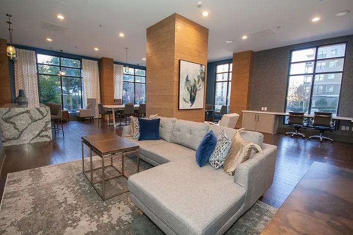 Modern apartment lounge with chic furniture, floor-to-ceiling windows, and elegant decor, perfect for relaxation and entertaining.
