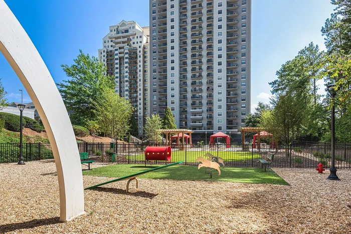 Modern high-rise apartments with a vibrant playground and lush greenery, offering a perfect family-friendly living environment.