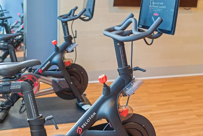 Modern gym with sleek exercise bikes featuring interactive screens, providing a contemporary fitness experience.