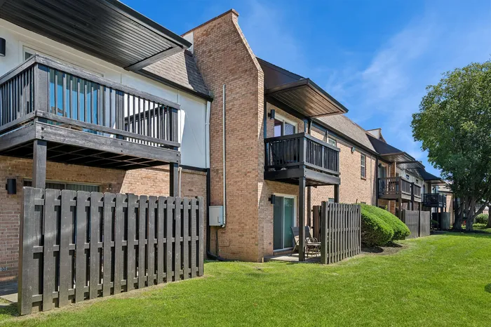 Charming brick apartments with private balconies and lush green lawns, ideal for modern living.