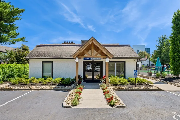 Charming suburban leasing center with modern architecture, lush landscaping, and inviting pathway in a serene neighborhood setting.
