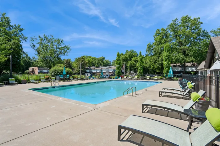 Inviting outdoor pool area with comfortable lounge chairs and vibrant greenery, perfect for relaxation and leisure.