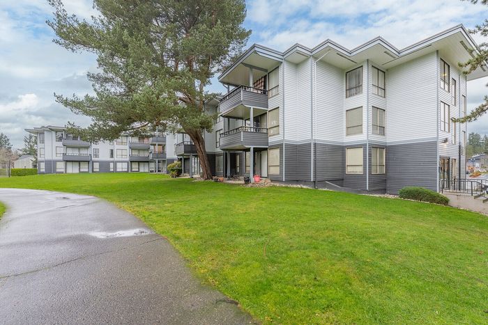 Charming apartment building nestled in a lush, green landscape with spacious balconies and a serene atmosphere.