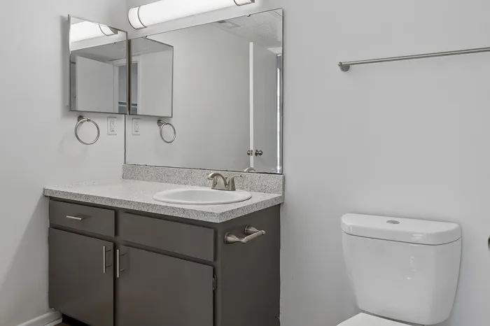 Modern bathroom featuring sleek granite countertop, elegant mirror, and stylish fixtures for a refined touch.