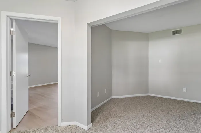 Inviting interior showcasing a bright, open doorway leading to elegantly carpeted and wooden spaces, perfect for a cozy home environment.