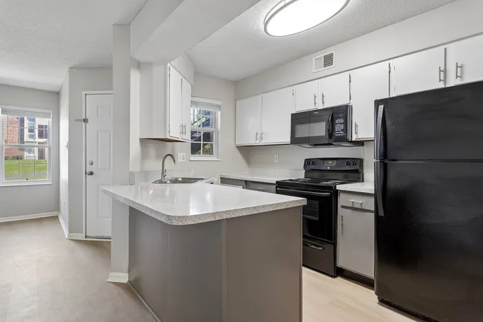Bright and inviting kitchen with modern appliances, sleek countertops, and plenty of natural light from large windows.
