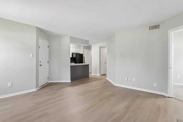 Bright and inviting open-concept living area with sleek wood flooring and a modern kitchen design.