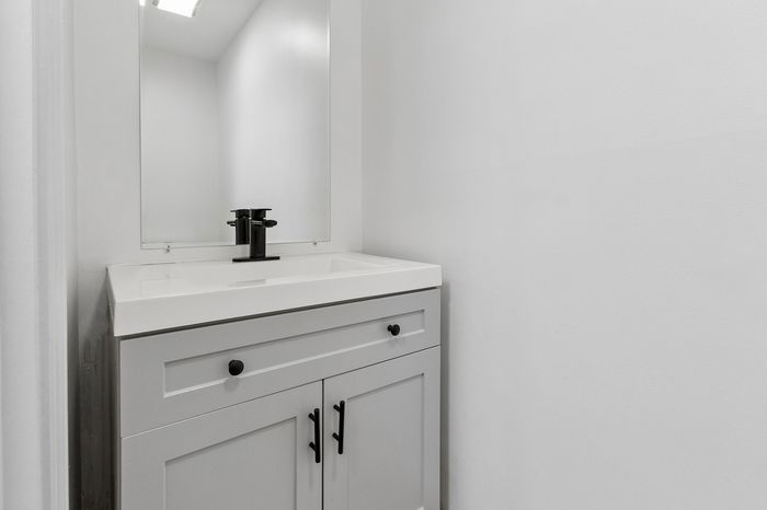 Sleek modern bathroom with minimalist design, featuring a pristine white vanity and elegant black fixtures.