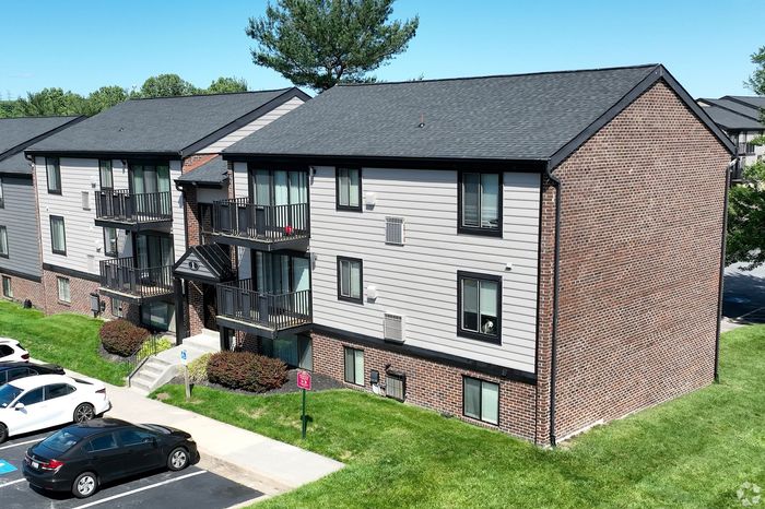 Charming apartment complex featuring modern design with private balconies, set in a lush, green neighborhood.