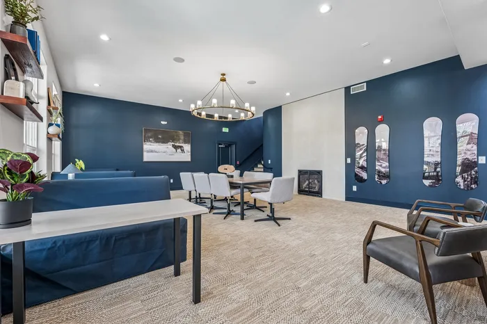 Elegant communal lounge with modern decor, featuring a chic chandelier, cozy fireplace, and stylish seating arrangements.