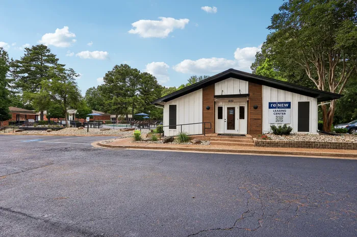 Inviting leasing center surrounded by lush greenery, featuring modern architecture and a well-maintained exterior.