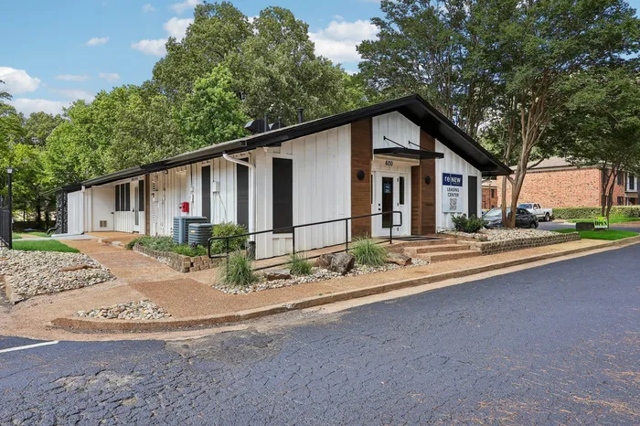 Charming leasing center surrounded by lush greenery and inviting pathways, perfect for welcoming new residents.
