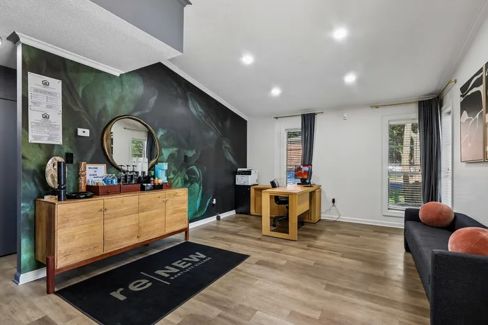 Inviting office space with modern decor, featuring a wooden desk, stylish wall art, and a chic seating area.